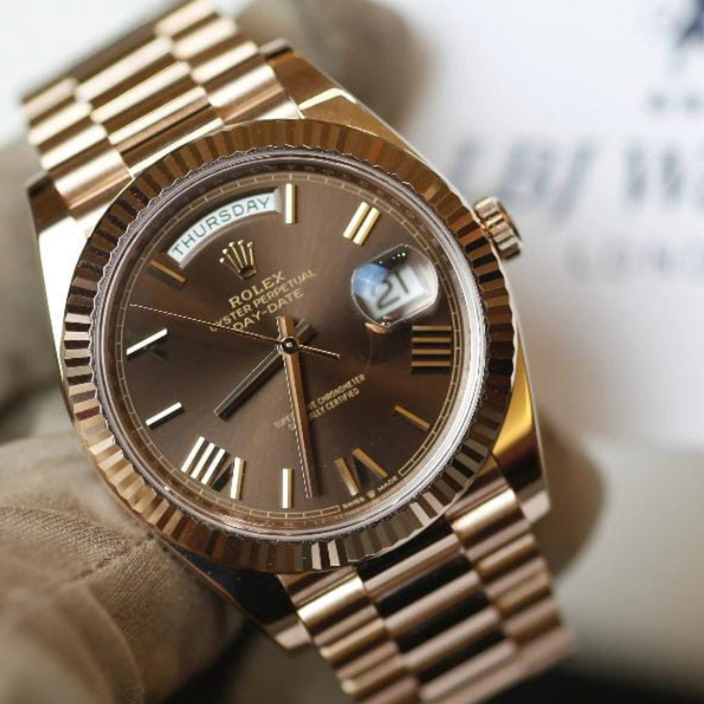 This is a Rolex Oyster Perpetual Day-Date Oyster Perpetual Day Date  with a chocolate dial, fluted bezel, and President bracelet.