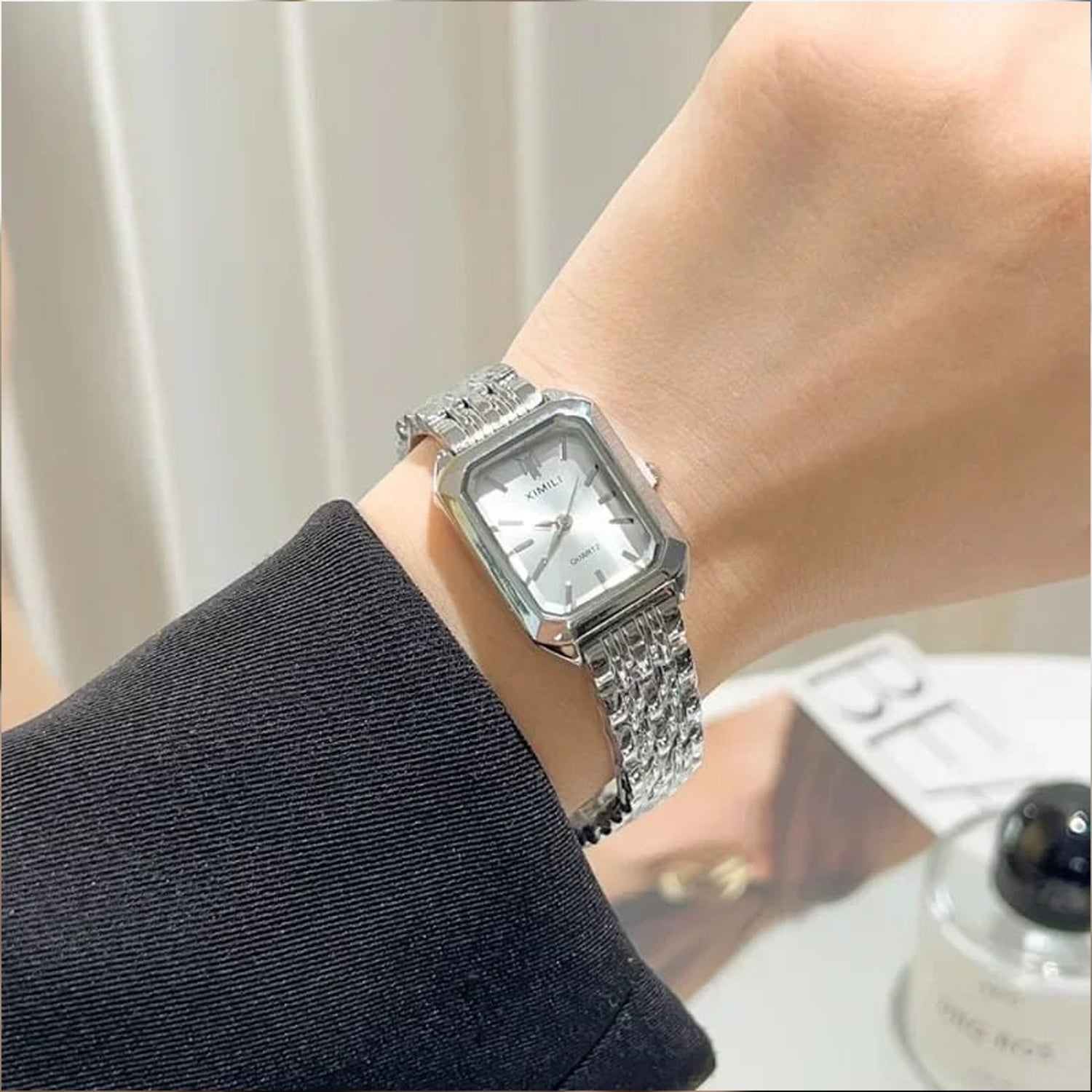 fashionable luxury quartz wristwatch designed for women, featuring a distinctive square case and a sleek silver-tone metal alloy strap.