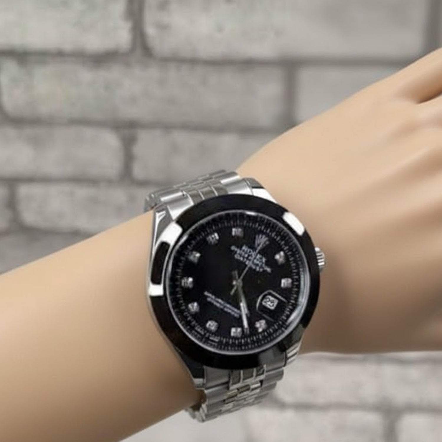 Rolex Datejust style watch featuring a black dial with stone markers and a stainless steel bracelet.